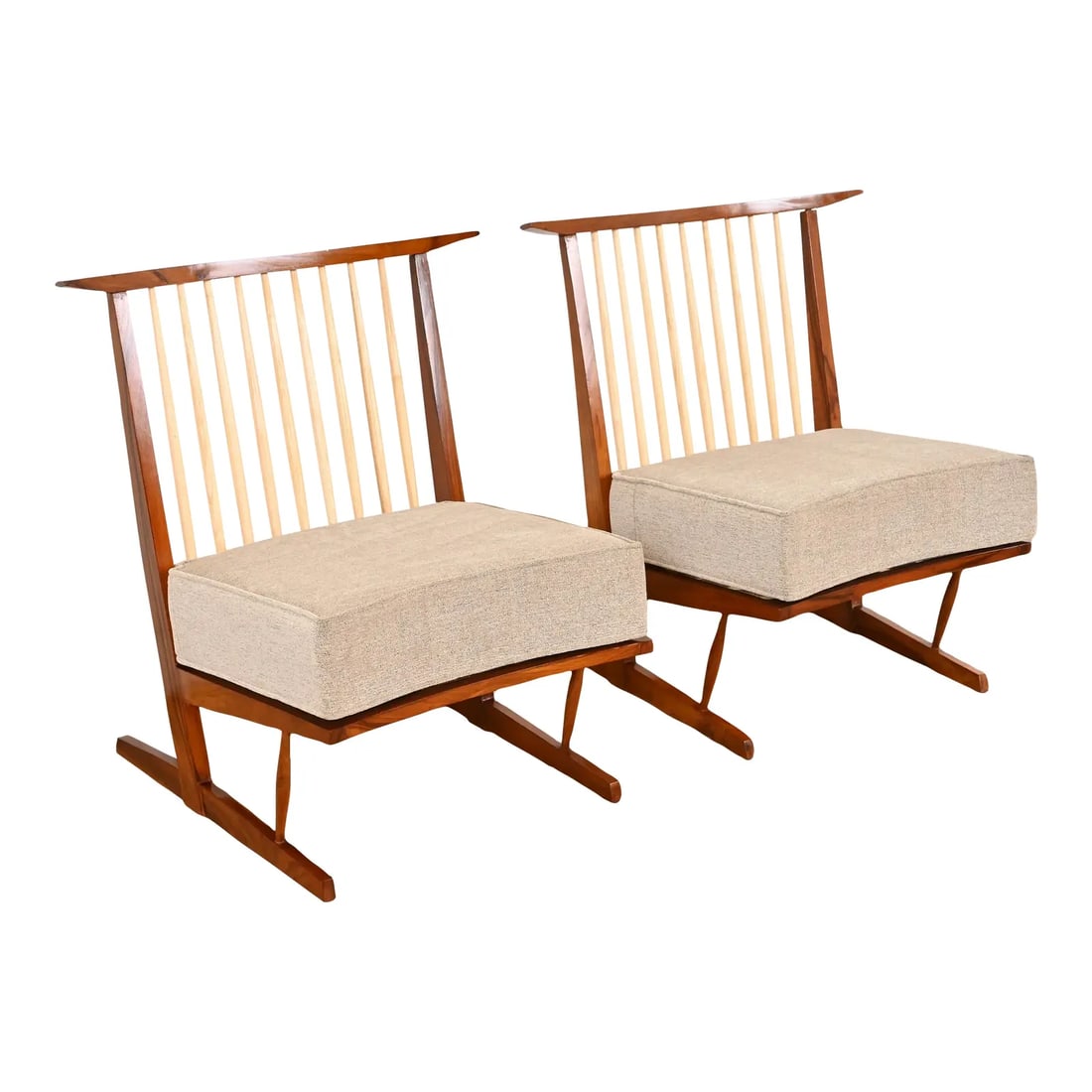 Conoid Lounge Chairs in Sculpted Walnut After George Nakashima, Pair: An exceptional pair of Organic Modern lounge chairs After George Nakashima USA, Circa Late 20th Century Sculpted walnut frames, with contrasting hickory spindles, and removable upholstered seat cushio
