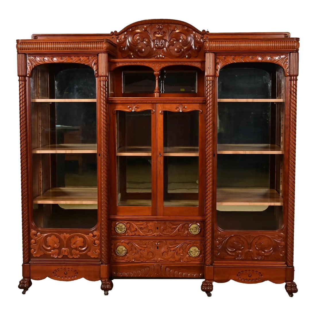 R. J. Horner Style Antique Victorian Carved Cherry Wood Triple Bookcase, Circa 1880s: An exceptional antique Victorian or Renaissance Revival triple bookcase, display cabinet, or bar cabinetIn the manner of R.J. Horner & Co.USA, Circa 1880sCarved cherry wood, with mirrored back