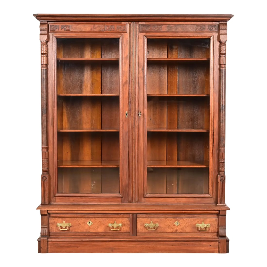 Herter Brothers Style Antique Eastlake Victorian Carved Walnut and Burl Wood Glass Front Bookcase: A gorgeous antique Eastlake Victorian two-door step back bookcase cabinet In the manner of Herter Brothers USA, Circa 1880s Carved walnut, with burled walnut panels, glass front doors, and original br