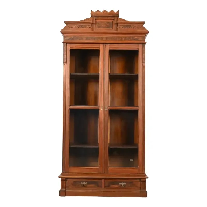 Herter Brothers Style Antique Eastlake Victorian Carved Burled Walnut Bookcase, Circa 1880s: An exceptional antique Eastlake Victorian bookcase In the manner of Herter Brothers USA, Circa 1880s Carved walnut, with glass front doors, burled walnut panels, and original brass hardware. Measures: