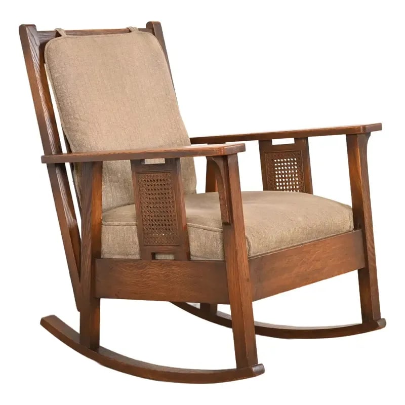 Stickley Brothers Antique Mission Oak and Cane Arts & Crafts Rocking Chair, Circa 1910: An exceptional antique Mission or Arts & Crafts period rocking chair By Stickley Brothers USA, Circa 1910 Solid quarter sawn oak frame, with caned side panels, and upholstered seat and back cushions.
