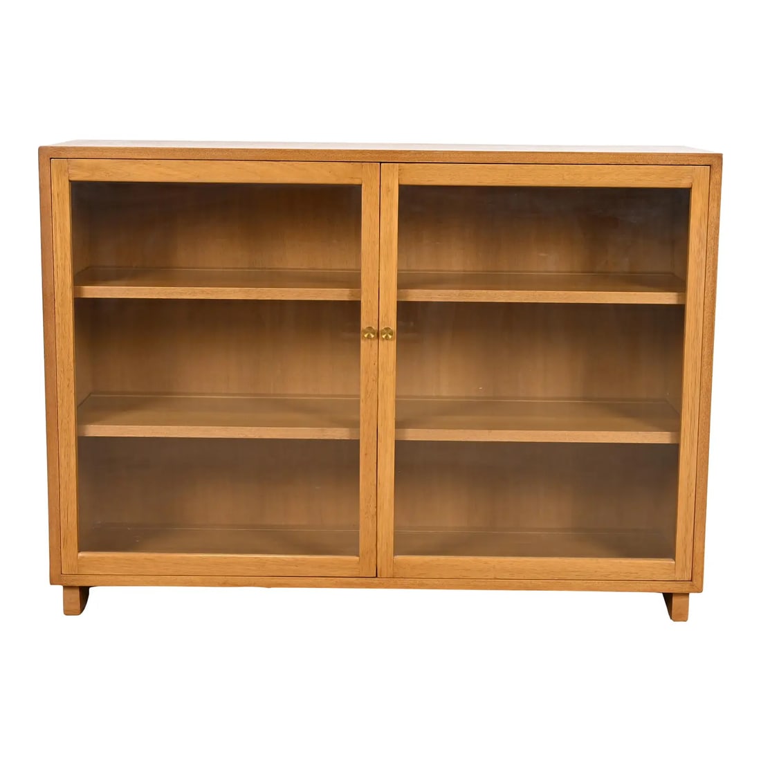 Edward Wormley for Dunbar Mid-Century Modern Mahogany Glass Front Bookcase, 1950s: A sleek and stylish Mid-Century Modern glass front bookcase or display cabinetBy Edward Wormley for Dunbar FurnitureUSA, 1950sBleached mahogany, with glass front doors and original brass hardware.