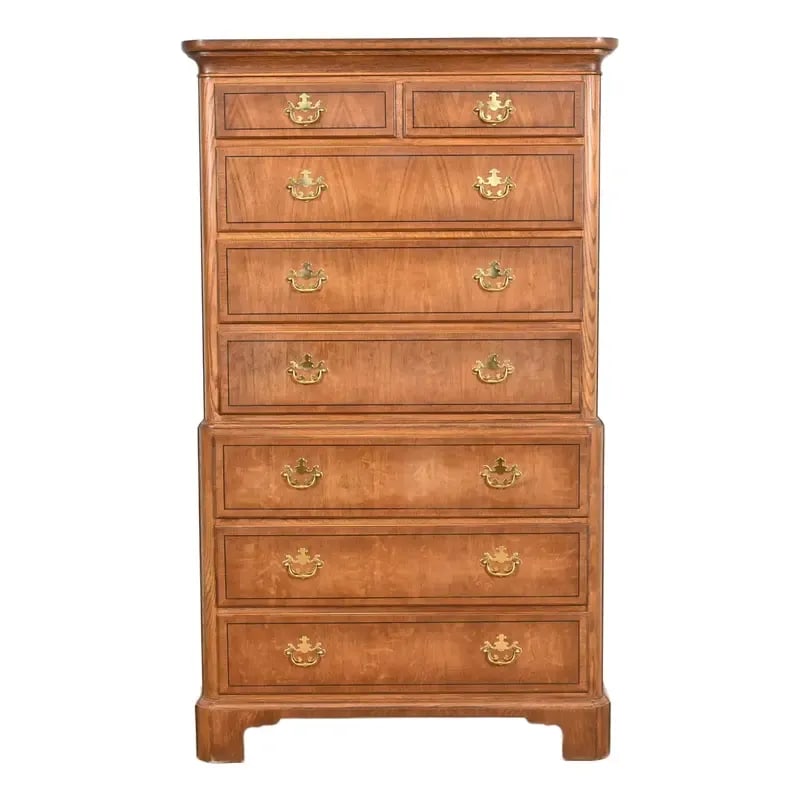 Baker Furniture Georgian Carved Oak Eight-Drawer Highboy Dresser: A gorgeous Georgian or Chippendale style eight-drawer highboy dresser or chest of drawers By Baker Furniture USA, Circa 1980s Carved oak, with original brass hardware. Measures: 39.75"W x 19"D x 66.75