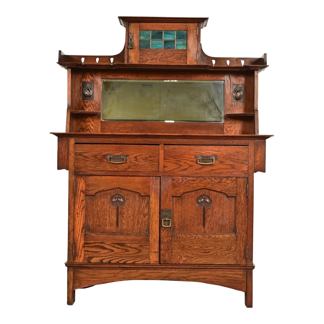 Liberty & Co. Antique English Arts & Crafts Oak Sideboard With Stained Glass Door, Circa 1900: A gorgeous antique Mission, Arts & Crafts, or Art Nouveau period sideboard, buffet server, or bar cabinet Attributed to Liberty & Co. England, Circa 1900 Gorgeous quarter sawn oak, with mirrored backs