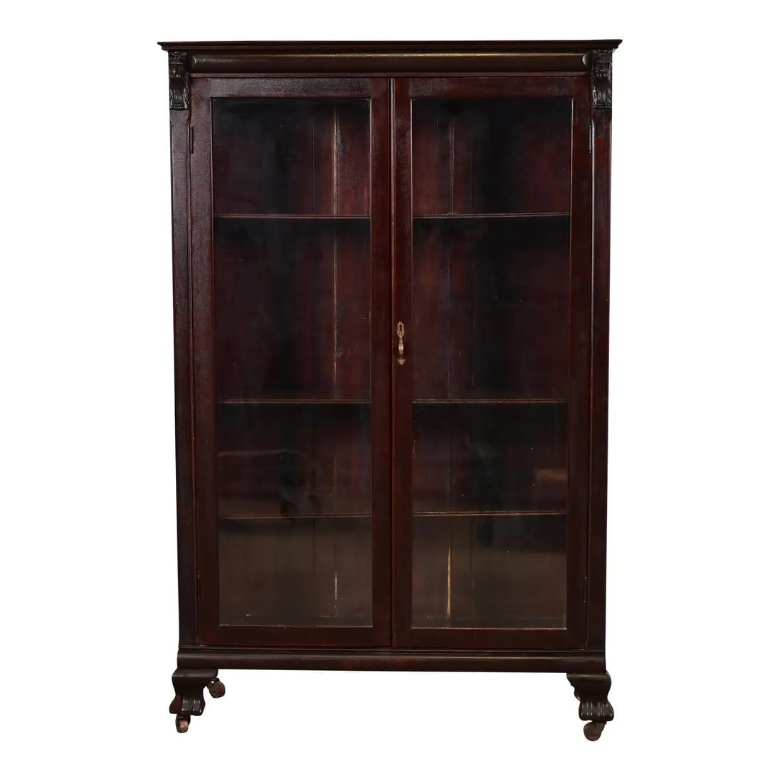 R. J. Horner Style American Empire Carved Mahogany Bookcase With Lion Heads, Circa 1890s: A gorgeous antique American Empire or Victorian bookcase cabinet In the manner of R.J. Horner & Co. USA, Circa 1890s Mahogany, with carved lion heads, and glass front doors. Interior shelves are adjus