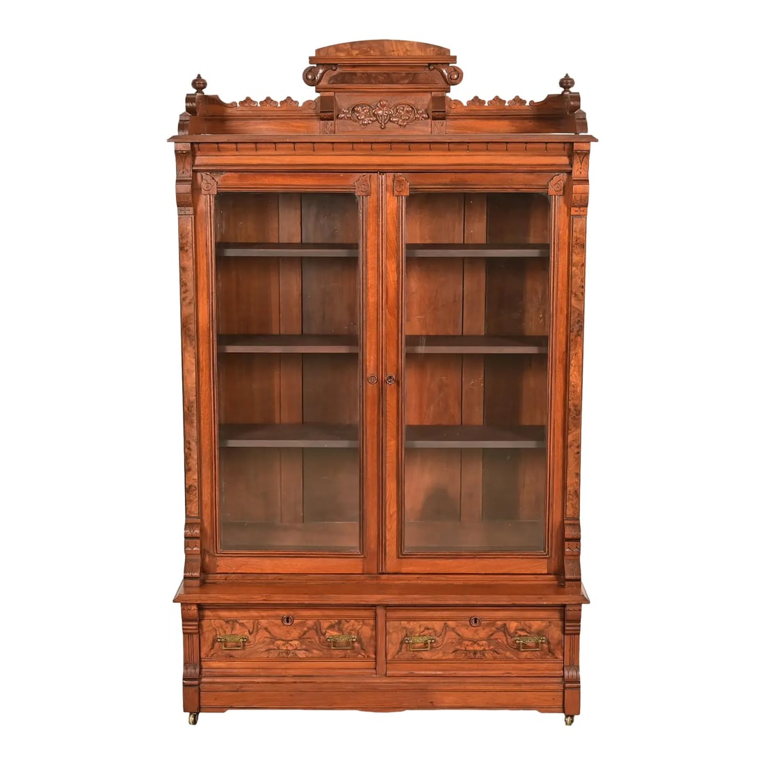 Herter Brothers Style Antique Eastlake Victorian Carved Burled Walnut Bookcase, Circa 1880s: An exceptional antique Eastlake Victorian bookcase cabinet In the manner of Herter Brothers USA, Circa 1880s Carved walnut, with burled walnut panels, glass front doors, and original brass hardware. M