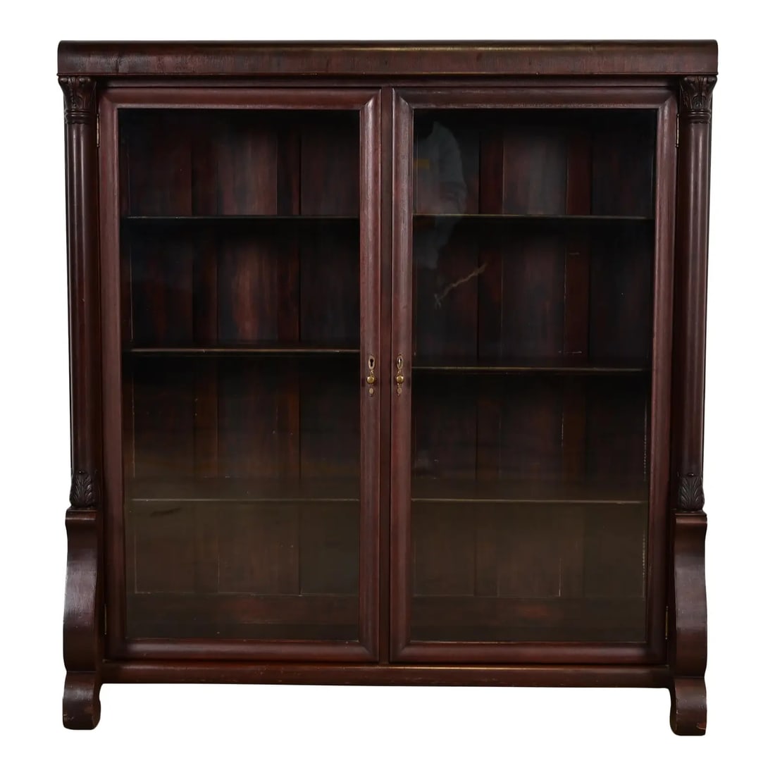 R. J. Horner Style American Empire Carved Mahogany Double Bookcase, Circa 1890s: An outstanding antique American Empire or Victorian bookcase cabinet In the manner of R.J. Horner & Co. USA, Circa 1890s Mahogany, with carved columns, glass front doors, and original brass hardware. 
