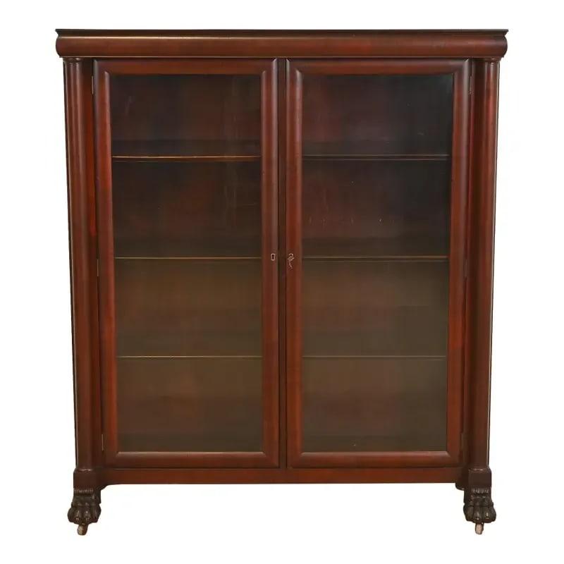 R. J. Horner Style American Empire Carved Mahogany Double Bookcase With Lion Paw Feet, Circa 1890s: An outstanding antique American Empire or Victorian bookcase cabinet In the manner of R.J. Horner & Co. USA, Circa 1890s Mahogany, with carved columns and lion paw feet, and glass front doors. Measure