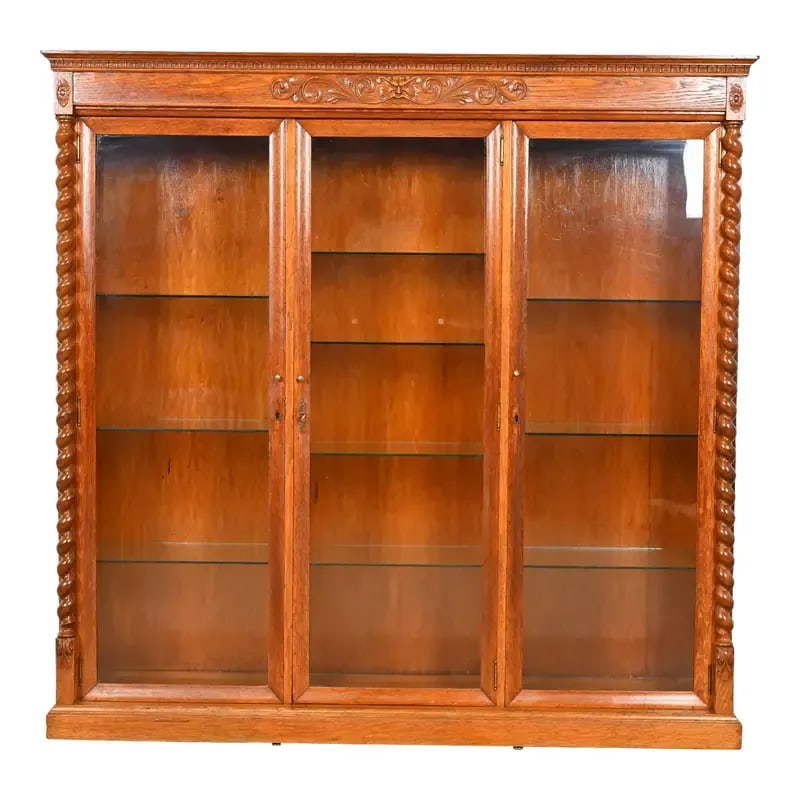 R. J. Horner Style Antique Victorian Carved Oak Lighted Triple Bookcase or Display Cabinet: A beautiful antique Victorian or Renaissance Revival lighted triple bookcase or display cabinet In the manner of R. J. Horner & Co. USA, Circa 1890s Carved oak, with glass front doors and brass hardwa
