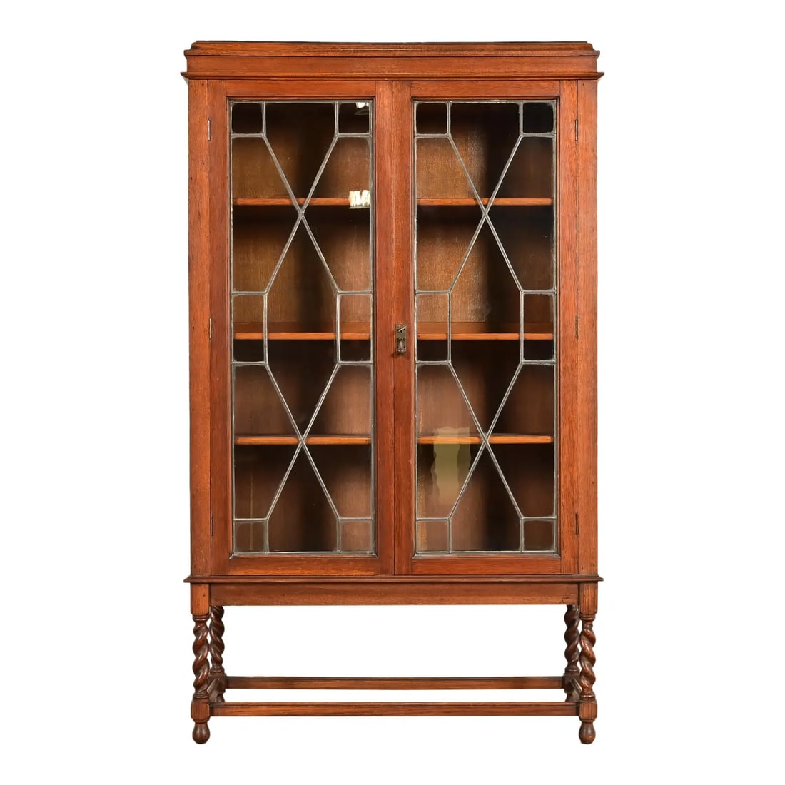 Stickley Brothers Style Antique Arts & Crafts Carved Oak Bookcase Cabinet With Leaded Glass Doors: A beautiful antique English Arts & Crafts or Late Victorian bookcase or display cabinet In the manner of Stickley Brothers England, Circa 1900 Oak, with mullioned leaded glass front doors, carved barl