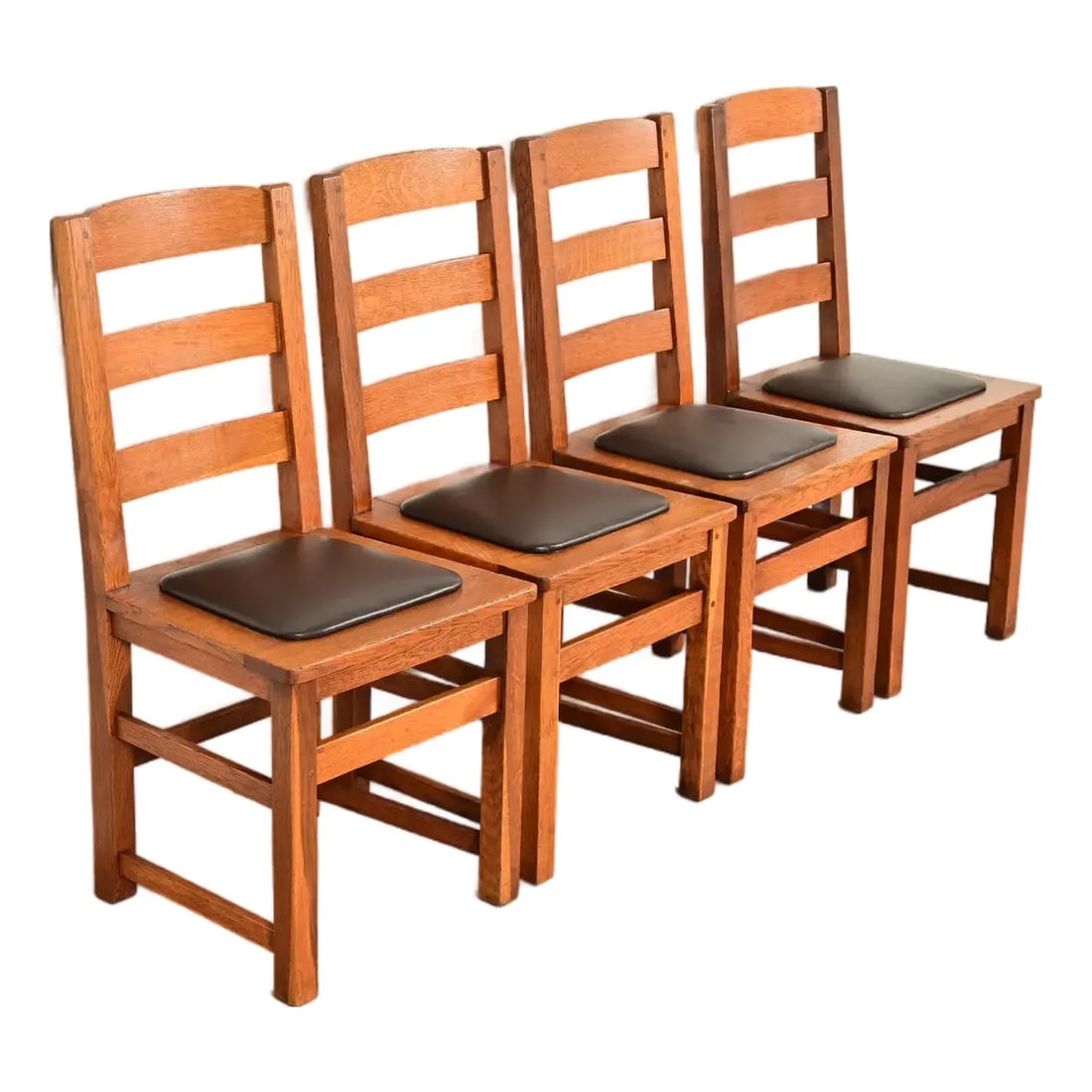 Limbert Antique Mission Oak Arts & Crafts Ladder Back Dining Chairs, Set of Four: A beautiful set of four antique Mission or Arts & Crafts ladder back dining chairs By Charles P. Limbert Co. USA, Circa 1910 Solid quarter sawn oak frames, with leather upholstered seats. Measures: 18