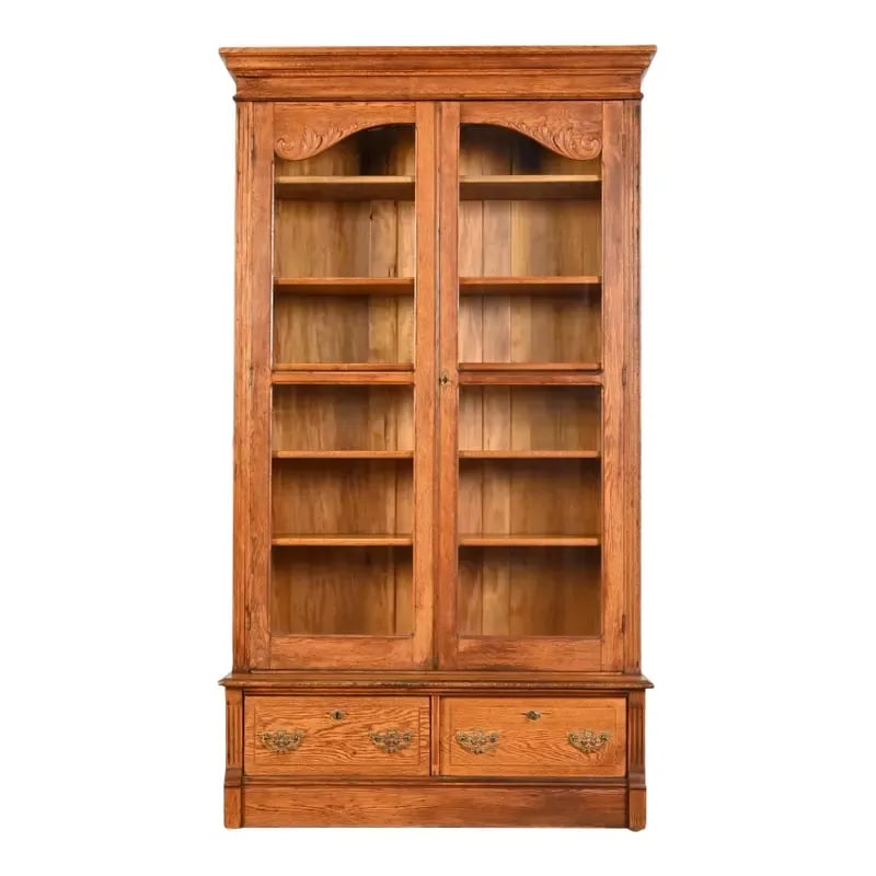 Antique Victorian Carved Oak Glass Front Bookcase, Circa 1900: A gorgeous antique Late Victorian or Arts & Crafts bookcase USA, Circa 1900 Carved oak, with glass front doors, and brass hardware. Cabinet doors and drawers lock. Two keys included. Measures: 44.5"W 