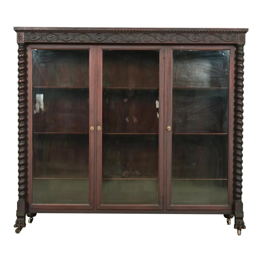 R. J. Horner Style American Empire Carved Mahogany Triple Bookcase With Lion Paw Feet, Circa 1890s: An outstanding antique American Empire or Victorian triple bookcase or display cabinet In the manner of R.J. Horner & Co. USA, Circa 1890s Mahogany, with carved columns and lion paw feet, and glass fr