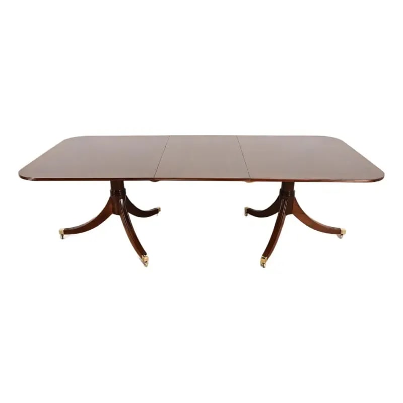 Baker Furniture Style Georgian Banded Mahogany Double Pedestal Extension Dining Table: An exceptional Georgian or Regency style double pedestal extension dining table In the manner of Baker Furniture USA, Circa Mid-20th Century Gorgeous banded mahogany, with carved solid mahogany pedest