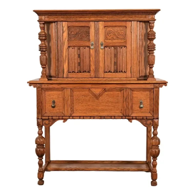 Antique English Jacobean Carved Oak Bar Cabinet, Circa 1920s: An exceptional antique English Jacobean, Victorian, or Renaissance Revival style bar cabinet In the manner of Berkey & Gay USA, Circa 1920s Measures: 44"W x 16"D x 56.5"H. Very good original vintage c