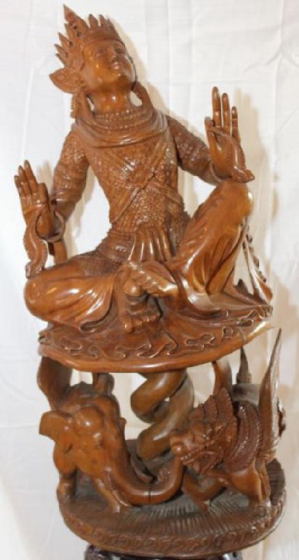 Southeast Asian carved wood figure of seated musician, (1 of 3)