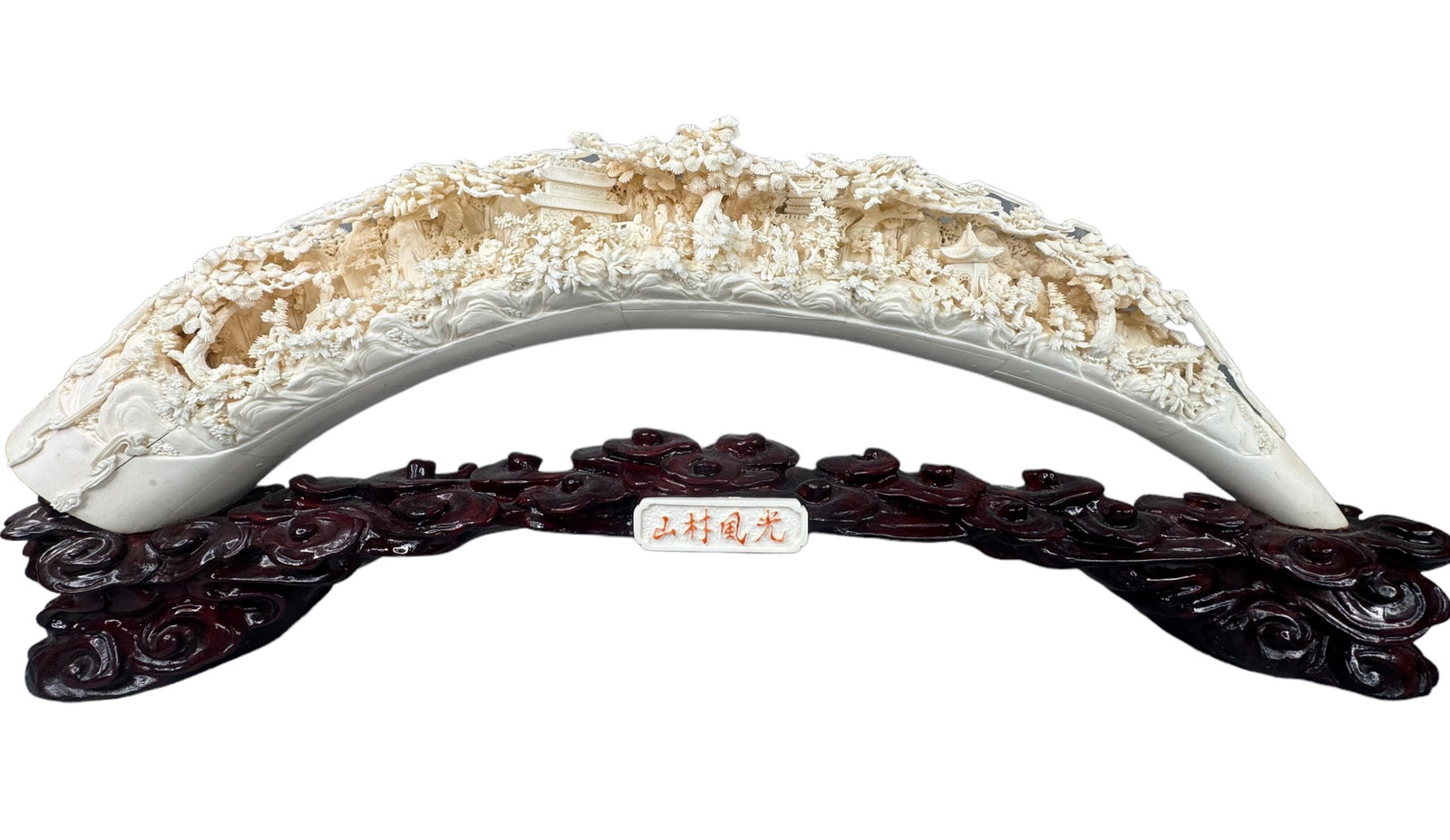 Intricately Carved Panel Bone Tusk Form: Beautiful intricately carved panel bone in a tusk form. The tiniest details make up an intricate scene of greenery, trees, people, dwellings, huts and animals. Fixed to a lacquered wood stand and ador