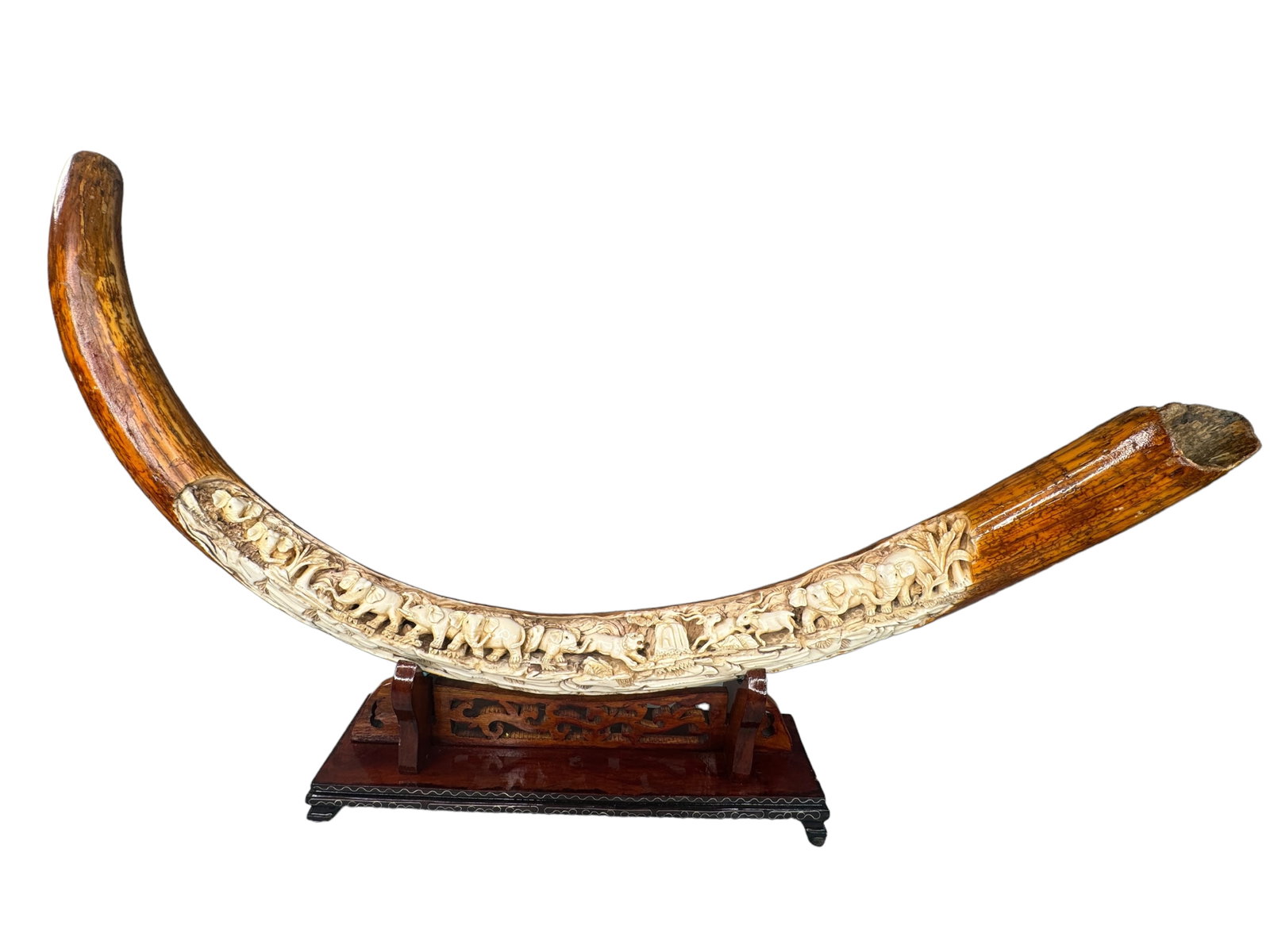 Carved Mammoth Tusk On Stand: Expertly carved elephants, kudu, tigers and more into a thin mammoth tusk. Natural outer tusk coloration in tact with preserving lacquer coating. Wood stand is also intricately carved with wire inlay.