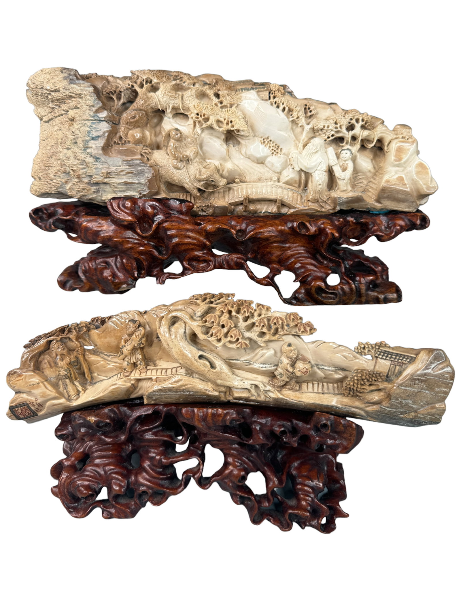 2 Carved Mammoth Tusk Pieces W/ Stands: Intricately carved mammoth tusk sections with Asian figures, animals and scenery. One is seal marked and translates XIN YI. Larger of the two is 11.5 x 4 inches without the stand. Both lacquered wood 
