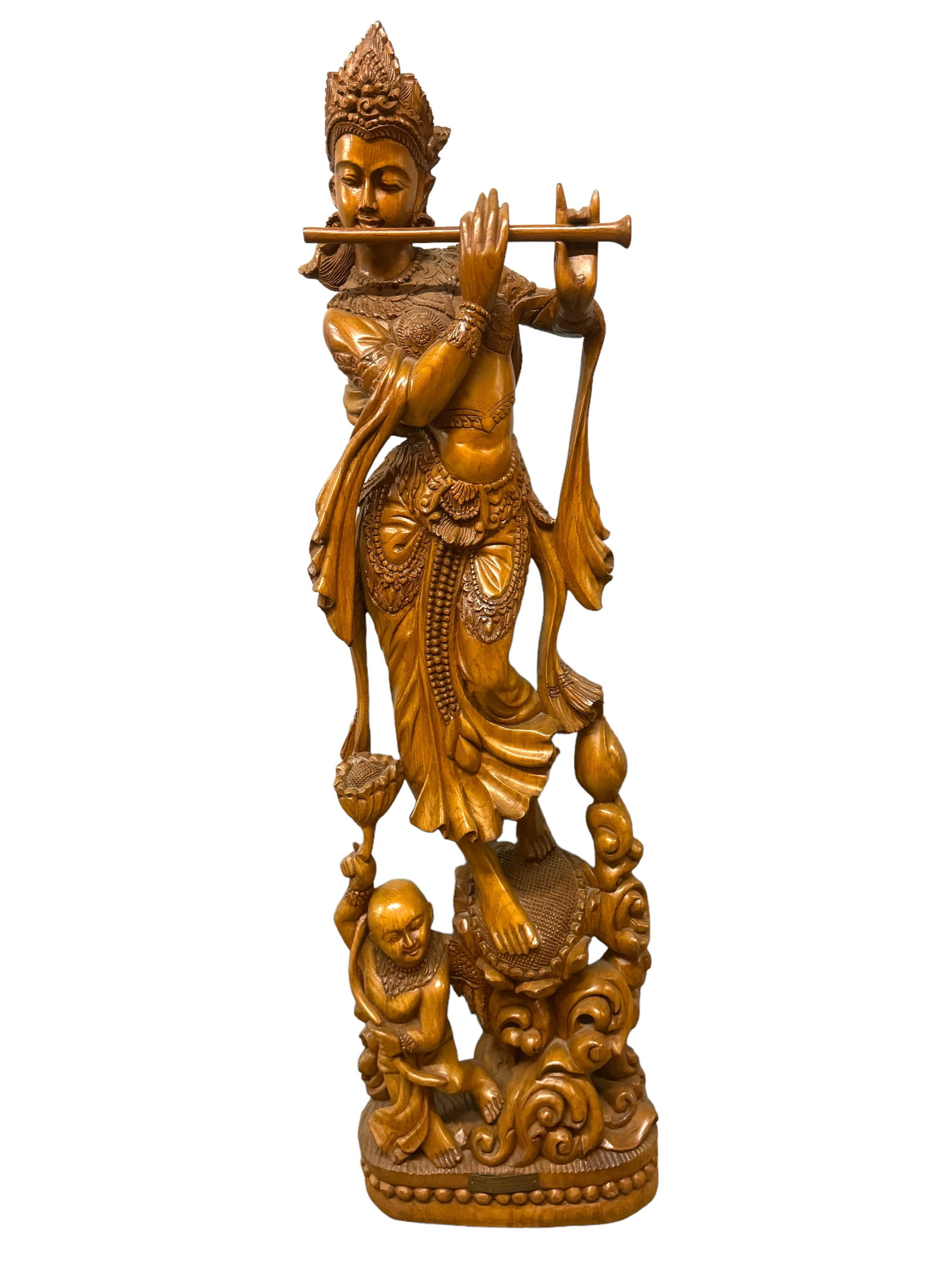 Tall Detailed Hand Carved Teak Thai Buddha Krishna: This vintage hand carved statue appears to be carved from a teak wood. Resembles the Thai Buddha Krishna with the flute. Highly detailed with added figures of florals and children around the base. Sta