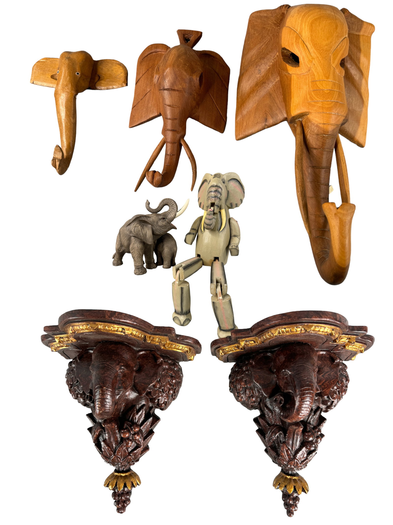 Kenyan, Indonesian, Asian Wood + Elephant Items: Kenyan carved elephant head wall hangers, Two resin elephant head sconces, Sedak ceramic elephant figure PLUS. Largest wall hanging is 12 inches in length.