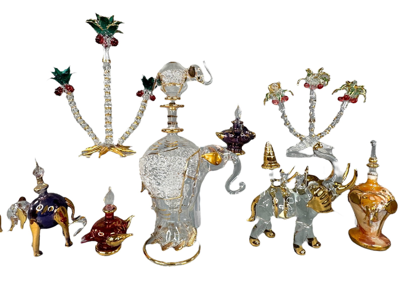 Blown Glass Figures With Gilt, Elephant & Trees: Most appear to be made in Thailand. Blown glass elephant figural bottles with stoppers, a crane, palm style trees and a larger bottle with elephant stopper. Tallest is 8.75 inches. One of the trees ha