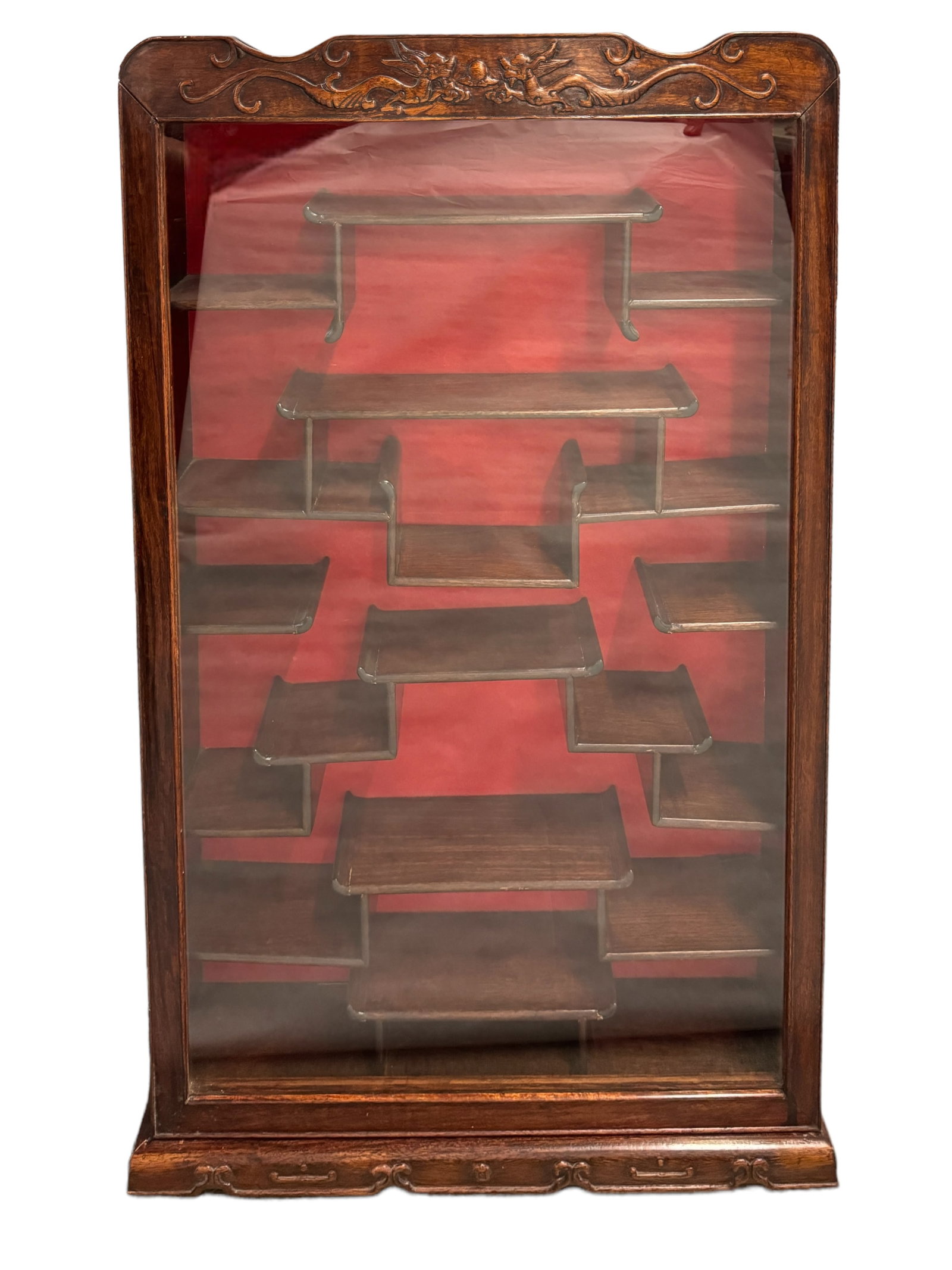Elaborate Asian Style Wall Display Cabinet: Beautiful wood Asian themed hanging wall display cabinet. Hinged glass door reveals a red backing with various key design shelving for bits and bauble display. Carved dragons in the top give it a rega
