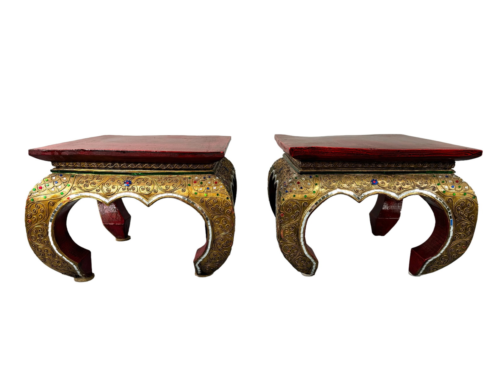 Thai Decorated Lacquered Wood Stools/Stands: Distressed red lacquered tops, signature Thai decorated bow legs with colorful glass and moriage style added effect in a gilt paint. Stools or plant holders. Each measures 11 inches tall by 13.5 x 14 