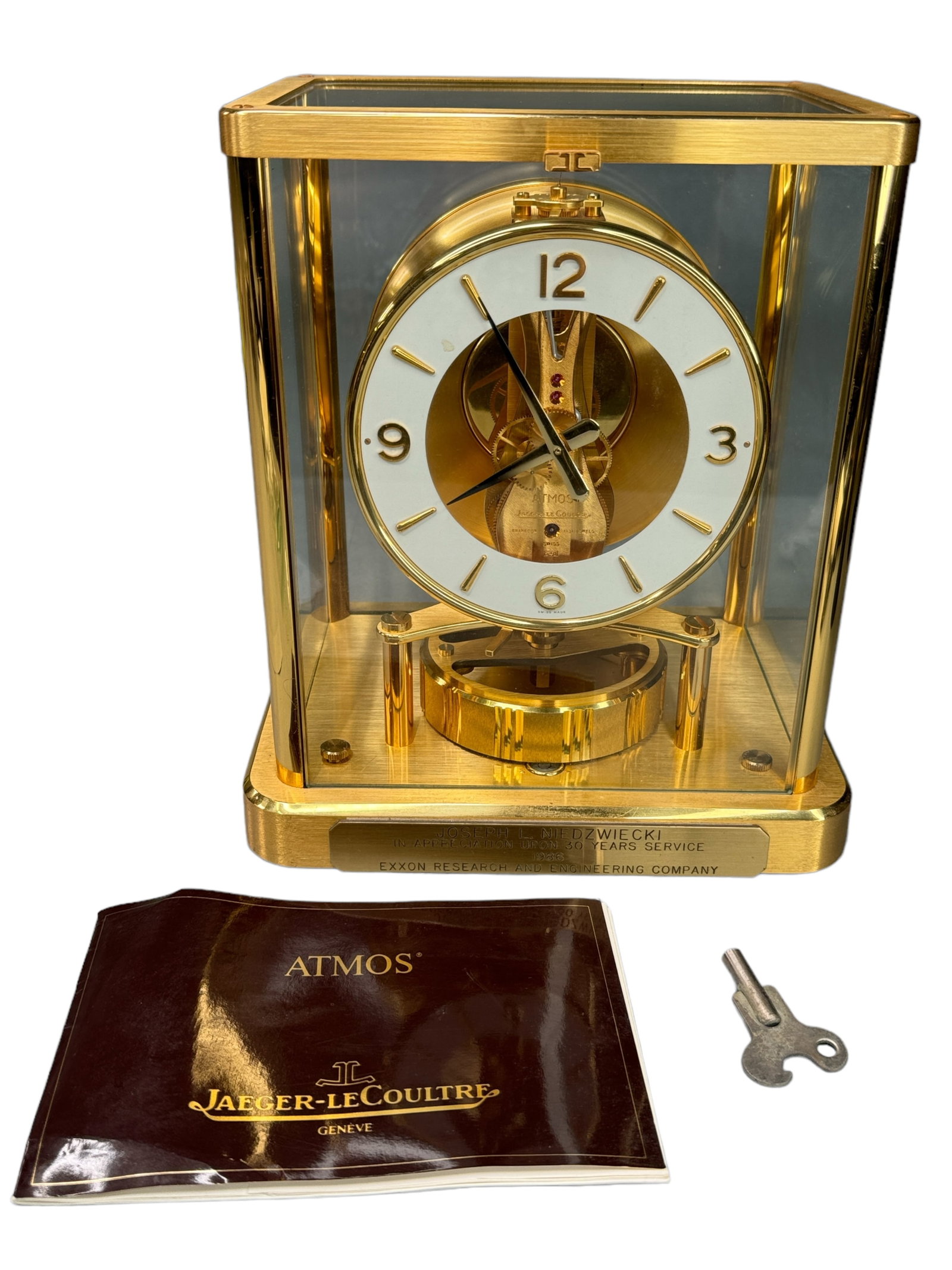 ATMOS LeCoulture Mantle Clock: Front inscribed plaque attributed to a gentleman for 30 years service with EXXON research and engineering co. Swiss workings, 5 sided glass with gold toned body and paperwork/key included. Untested. M