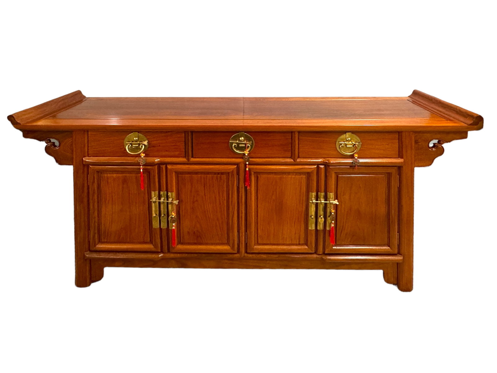 Exquisite Chinese Rosewood Style Altar Sideboard: This vintage large Chinese sideboard has brass toned holds with tassel decorated pins and drawer pulls. Possibly a huanghuali wood, but has a rosewood tone. Three top drawers and two sets of hinged do