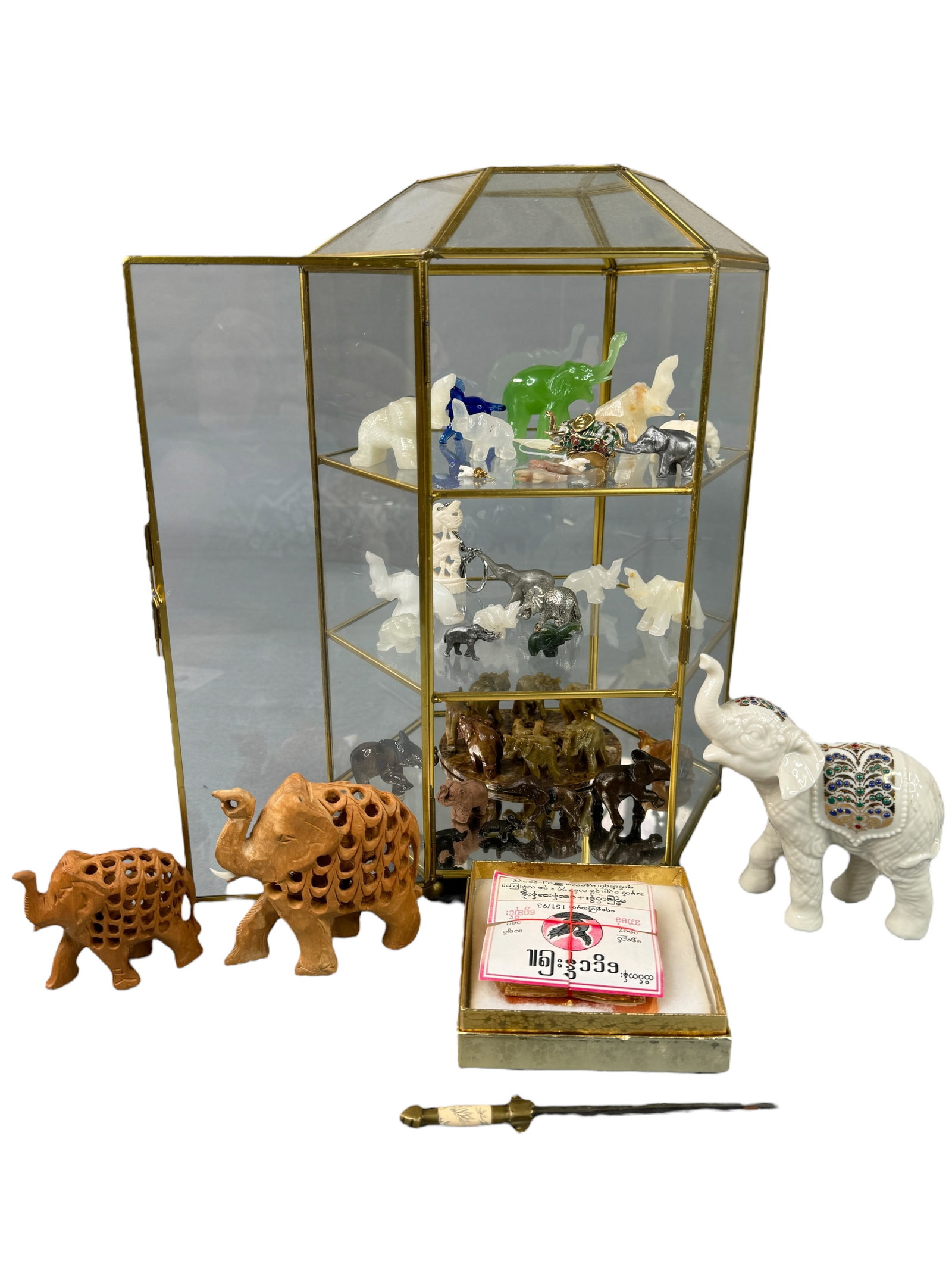 Stone, Metal, Wood Enamel Elephants Collection: Several carved stone, bone, wood, cast metal, glass, ceramic and enameled small elephant trinkets of varied sizes between 0.5 of an inch to 3 inches. Includes a Lenox China Jewels Collection ceramic 5