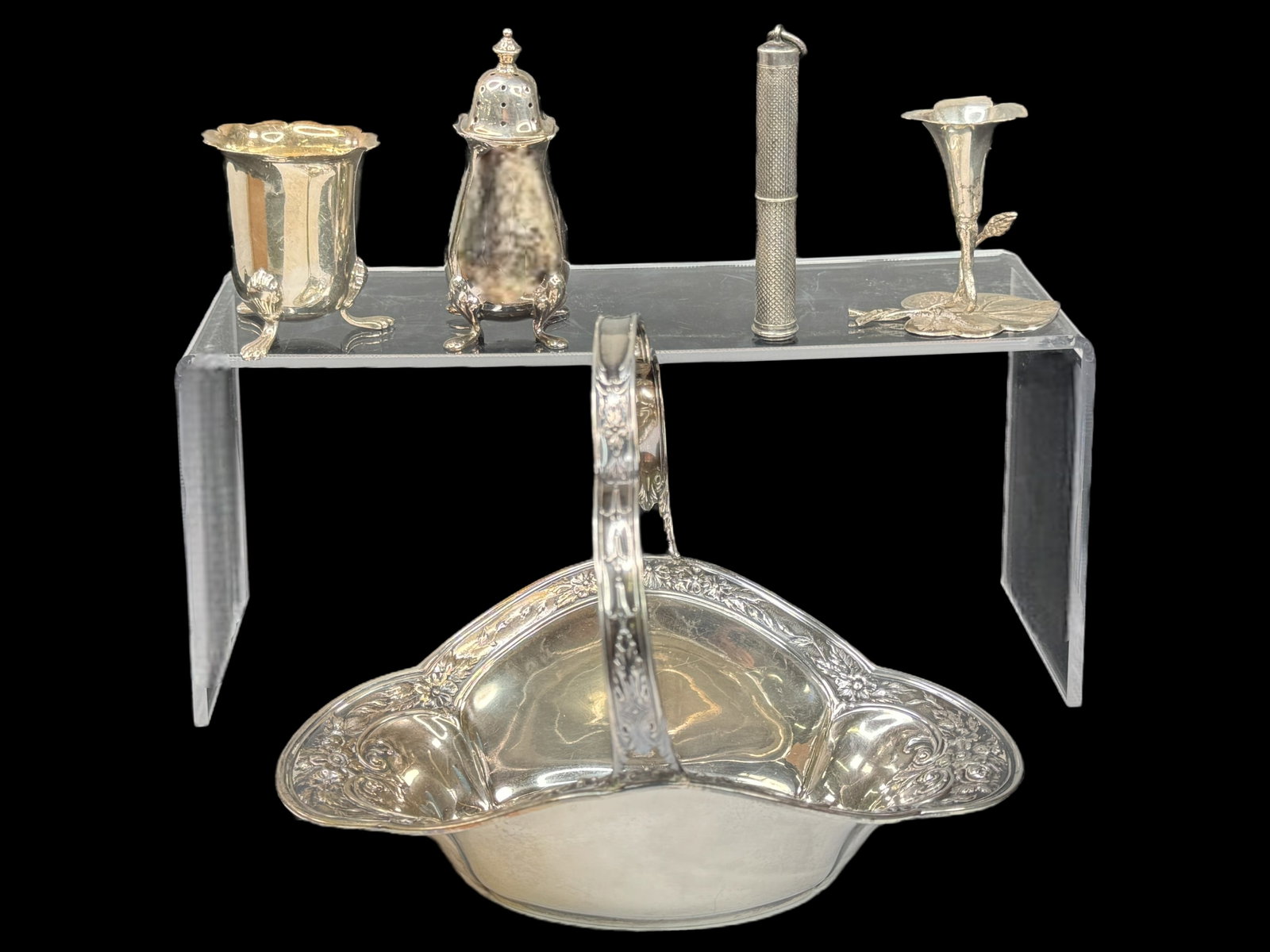 International Sterling Basket, Small Sterling Pieces: International Sterling repousse nut basket. Measures 5 x 6.5 x 4.75 inches. Unmarked sterling floral small candle holder is 2 inches tall, a salt and pepper footed shaker hallmarked is 3 inches tall. 