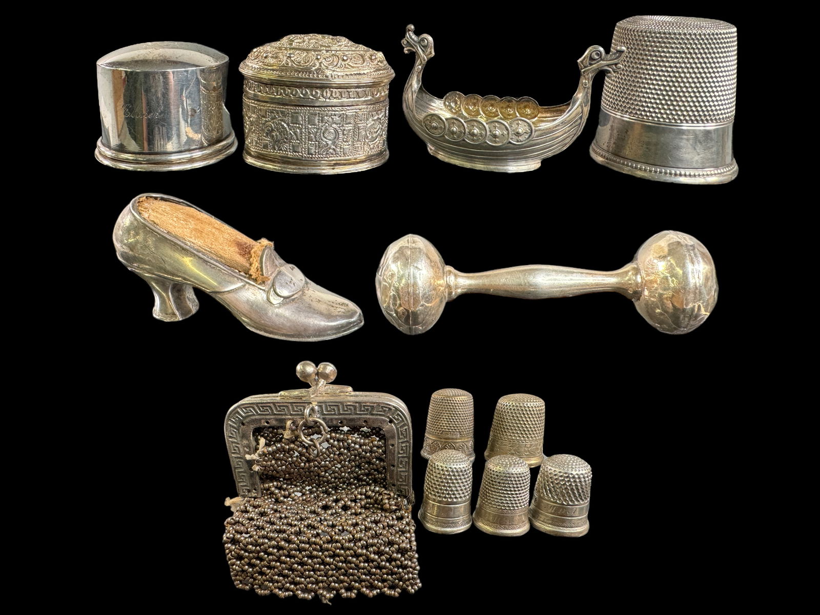 Sterling Victorian Trinkets Lot: Sterling shoe pin cushion hold, Oversized thimble trinket, three small thimbles, a WEBB sterling baby rattle, A Norge little boat , a STUNNING Asian repousse trinket box with a lid, and a monogrammed