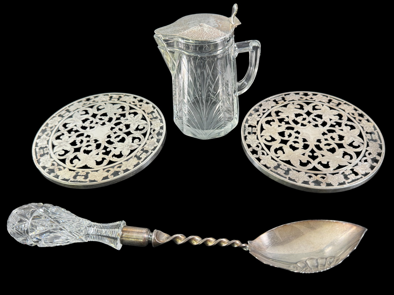 ABP Cut Glass & Sterling, Webster Sterling Trivets: Brilliant cut glass syrup pour vessel with hallmarked sterling lid stands 4.75 inches. Cut handle with Gorham marked spoon is 11.5 inches in length, 2 Webster marked sterling overlay glass trivets are