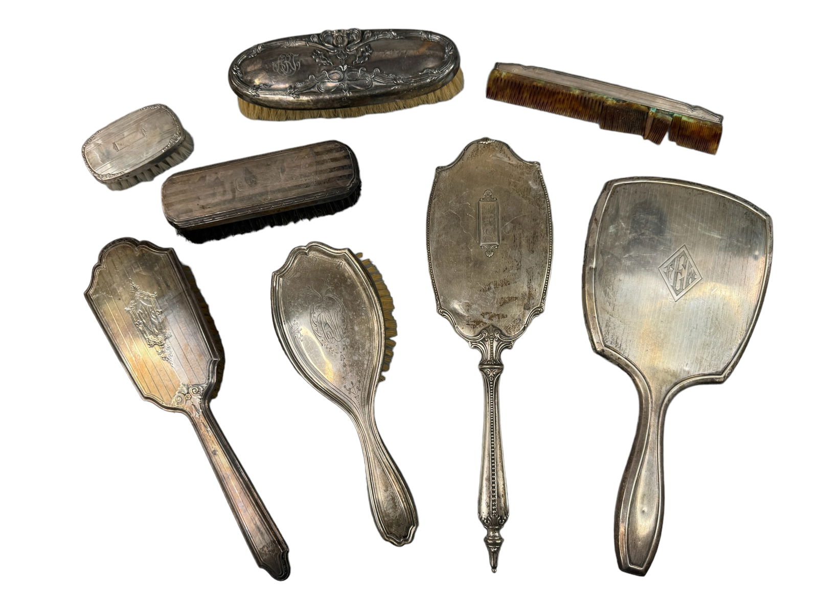 Sterling & Plated Victorian Grooming Pieces: 2 Marked sterling brushes, one is 10.5 inches, one is 9 inches. Two sterling marked hand mirrors; One is cracked. One measures 13 inches, the other 11.75 inches. Two marked sterling clothing brushes.