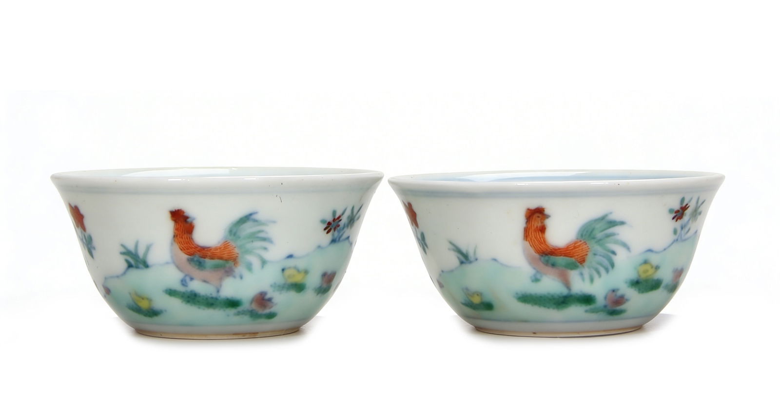 A Magnificent Pair of Doucai 'Chicken' Cups: H :2.8cm D :6.4cm This superb pair of cups faithfully revives the iconic Chenghua prototype in both form and decoration. Painted in exquisite doucai enamels, each exterior depicts a charming scene of