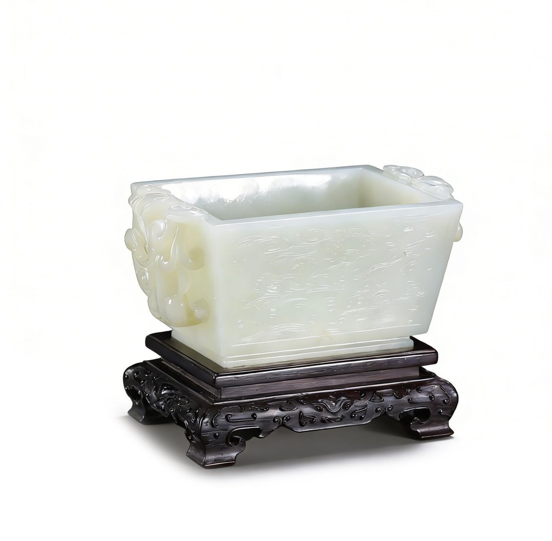 A Fine Chinese Pale Celadon Jade Rectangular Vessel with Chilong Handles, Qing Dynasty, Qianlong: L :11.5cm W :6.5cm H :5.5cm Weight :303g A fine Chinese pale celadon jade rectangular vessel, Qing Dynasty, Qianlong period, carved with low-relief cloud and wave motifs, and fitted with chilong handl