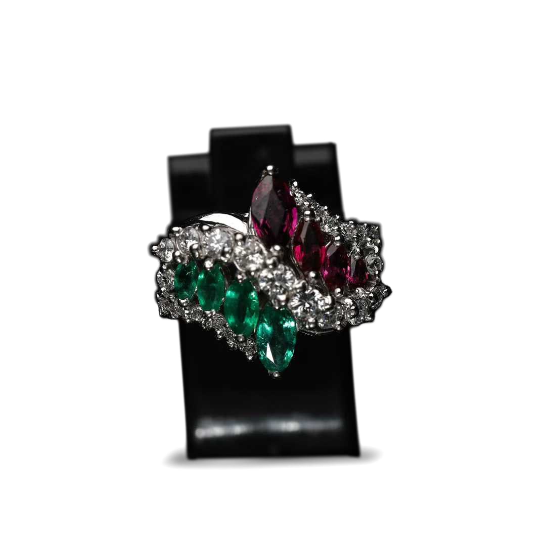 RETRO Period, Platinum Ring with Emeralds, Rubies and Diamonds: Emerald : 0.5 ctRuby : 0.7 ctDiamond : 0.48 ctTotal Weight : 11.35 g A luxurious platinum ring from the RETRO Period, crafted in PT950 platinum with a thick and substantial setting of excellent textur