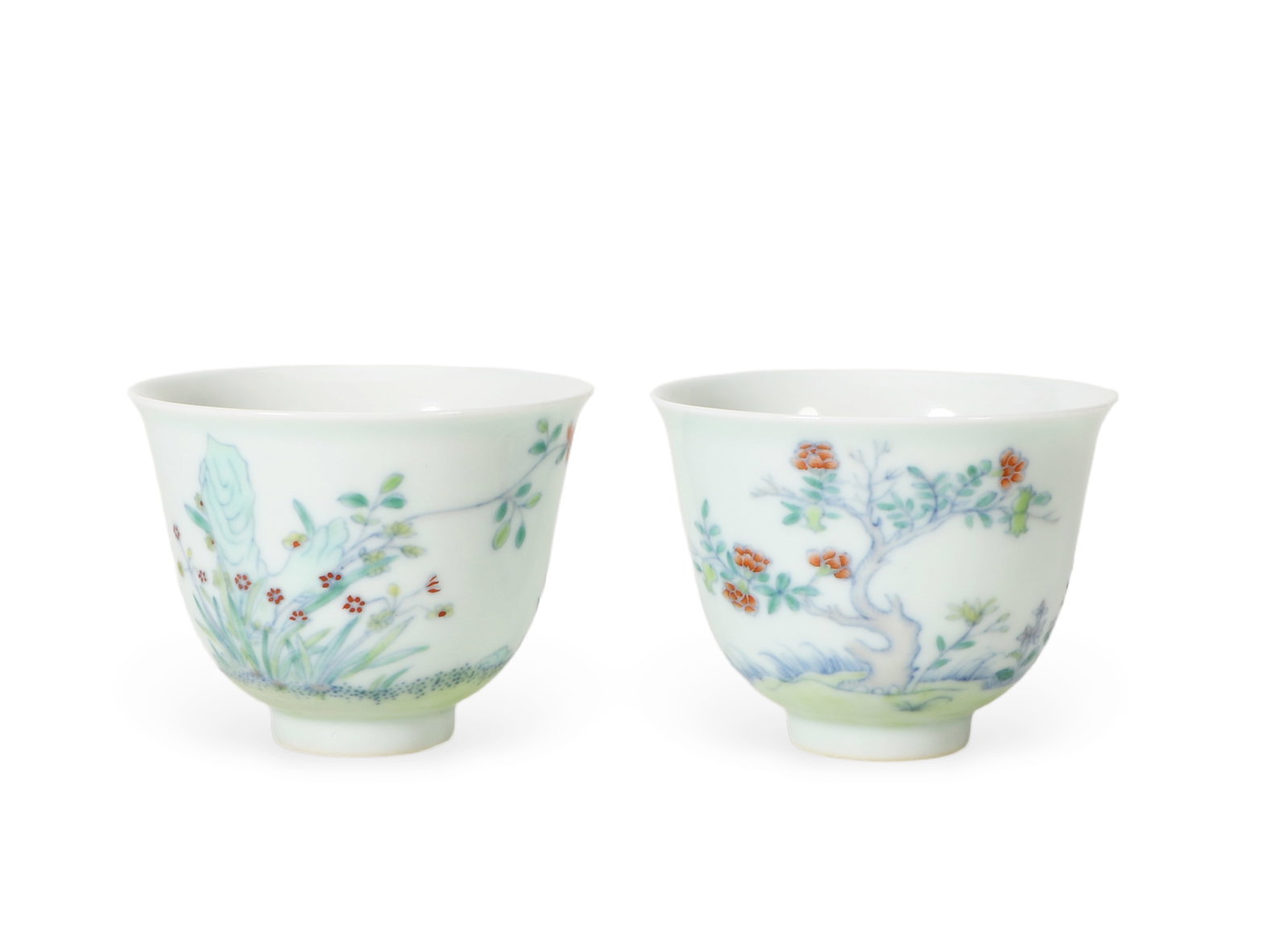 Pair Of Doucai Floral-Fruit Bell Cups: H:5cm D:6.5cm Matching pair of Qing official doucai bell tea cups, complementary orchid-rock and pomegranate-fruit motifs, classic underglaze outline plus overglaze fill technique, thin translucent gl