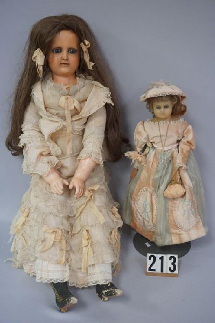 (2 PIECES) 34 INCH WAX OVER MACHE SHOULDER: HEAD WITH GLASS EYES, PIERCED EARS & OPEN MOUTH WITH FOUR UPPER TEETH, WAX FOREARMS & HANDS, MACHE LEGS, CLOTH BODY (NOT ORIGINAL), THIGH SECTION OF LEGS TAPED TO MACHE LOWER LEGS, MOLDED BOOTS ARE WO