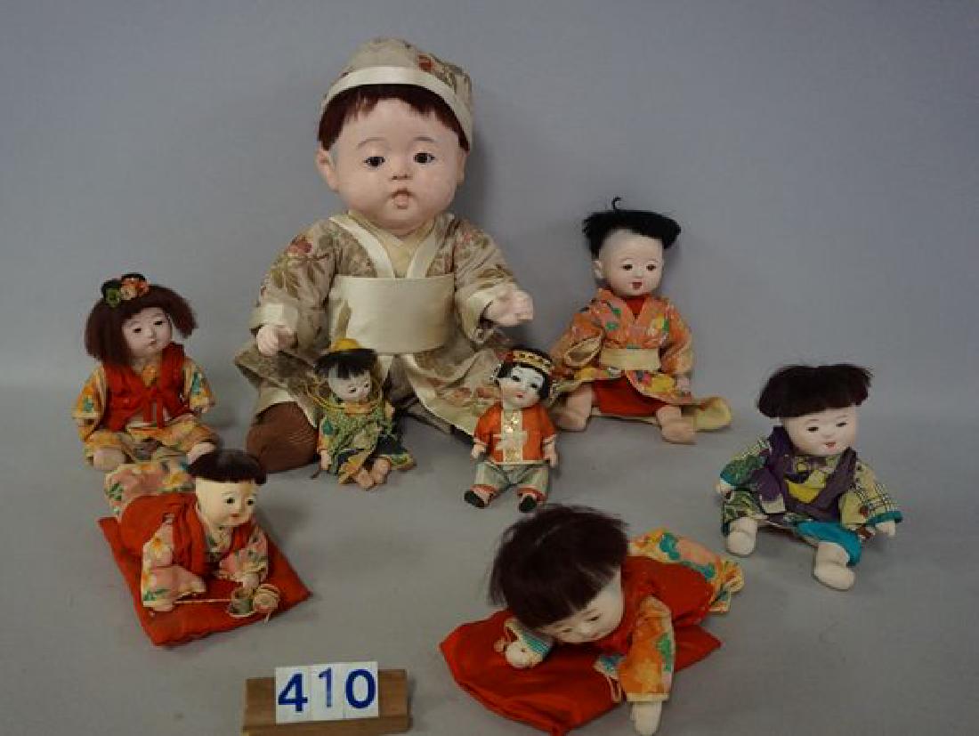 (8 PIECES) ASIAN BABY DOLLS:: 17 IN. PAPIER MACHE WITH FIVE-PIECE MACHE BODY, FACE HAS A BUMP ON THE NOSE, SOME SCUFFS & PAINT LOSS ON CHEEKS - FAIR, (6) ASSTD. SIZE MACHE BABIES (5 1/2 IN. - 10 IN.), STRINGING IS LOOSE ON SOME - 
