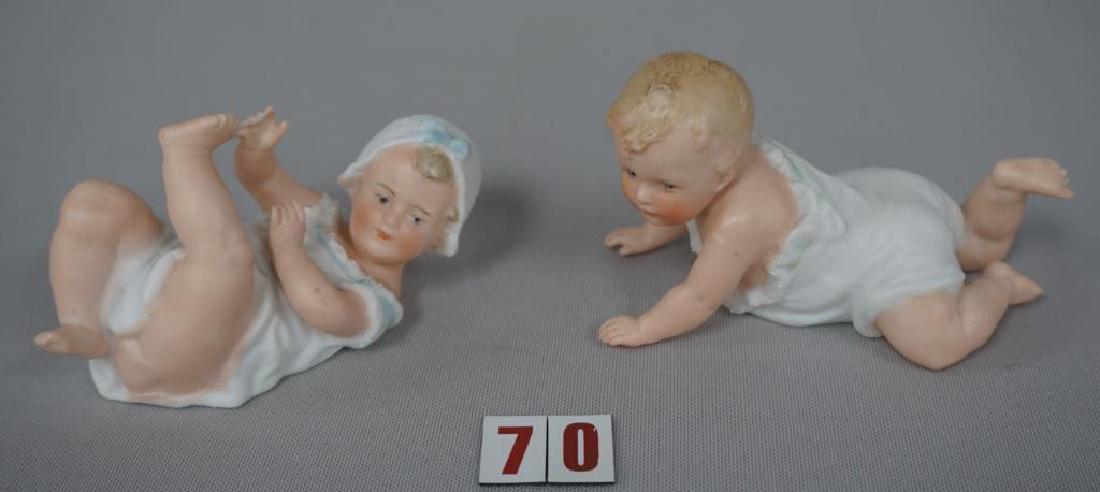 (2 PIECES) HEUBACH (SIGNED) BISQUE PIANO BABIES:: (2 PIECES) HEUBACH (SIGNED) BISQUE PIANO BABIES: CRAWLING BABY (2 1/2 IN. H, 4 IN. L), HAS THUMB MISSING ON LEFT HAND & BABY IN BONNET (2 IN.H, 4 IN. L) HAS TWO FINGERS WITH CHIPS ON THE RIGHT HAND