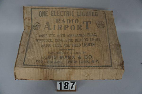 MARX TIN LITHO RADIO AIRPORT,: ELECTRIC LIGHTED WITH ORIGINAL CLOTH WIRES ON BASE, WINDSOCK, INSTRUCTIONAL & SIGNALING CODE SHEETS, (1) 5 IN. LONG PLASTIC AIRPLANE, MISSING (3) BULBS. FLAG & SEVERAL AIRPLANES - GOOD, WITH ORIGINAL