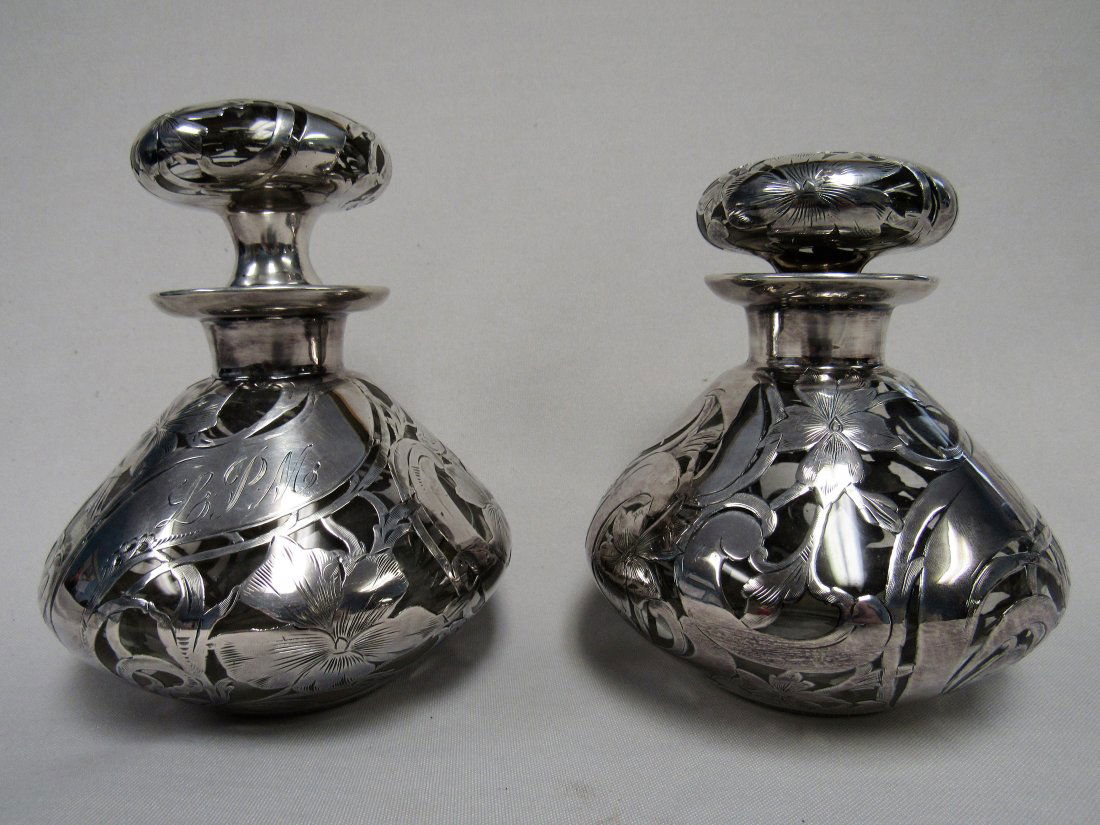 PAIR OF SILVER OVERLAY BOTTLES:: (2) 6 IN. COLOGNE BOTTLES WITH HEAVY SILVER OVERLAY. EACH HAS A FAINT 'FINE' SILVER MARK. BOTH MONOGRAMMED WITH L P M INITIALS - VG