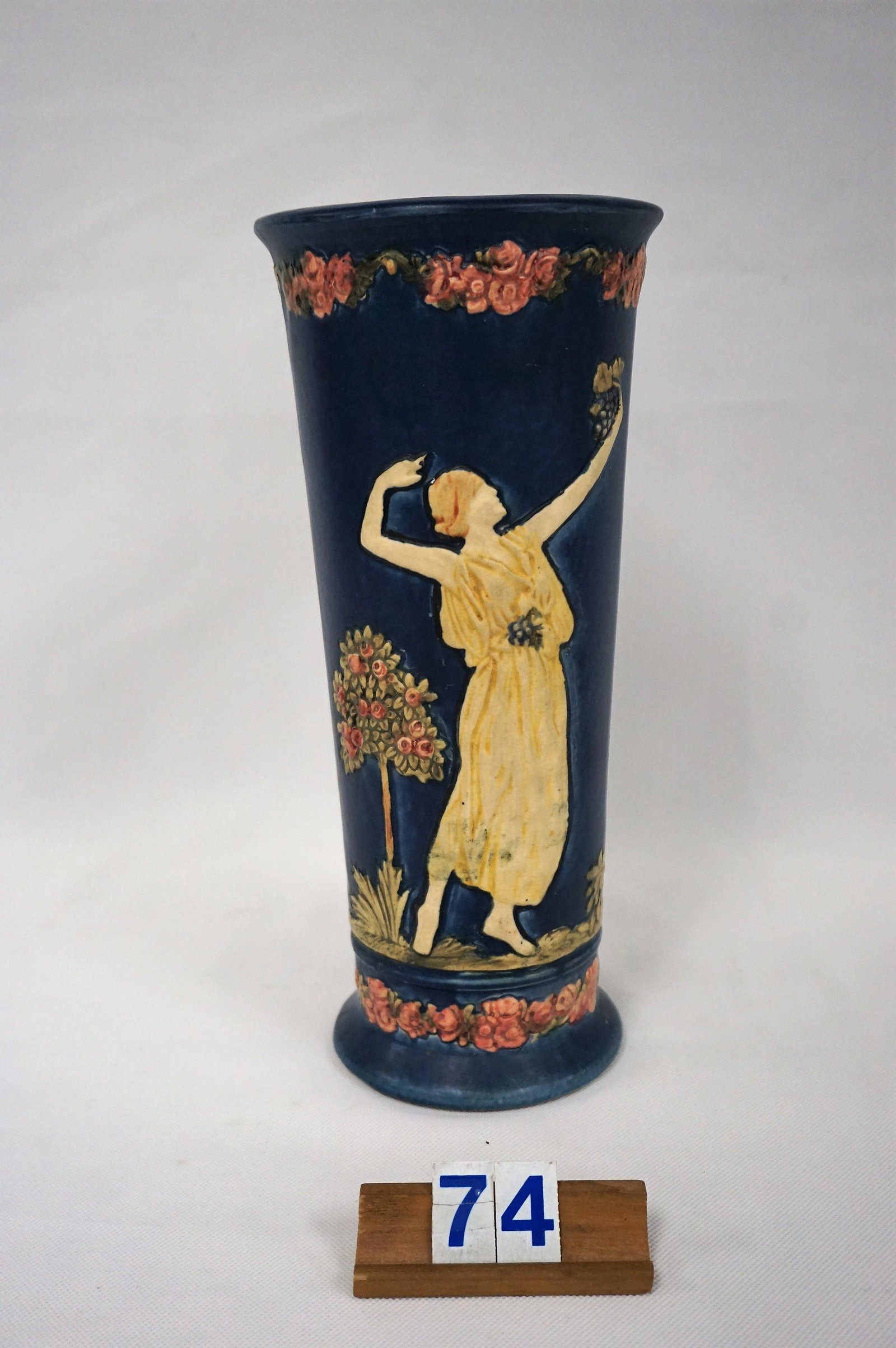 WELLER POTTERY BLUE WARE VASE WITH GRECIAN WOMAN: HOLDING GRAPES, TWO DIFFERENT POSES, 12 IN. H, 5 1/4 IN. W AT TOP & 4 1/4 IN. W AT BASE - NO DAMAGE OR REPAIRS, CIRCA 1915 - 1920, VERY GOOD