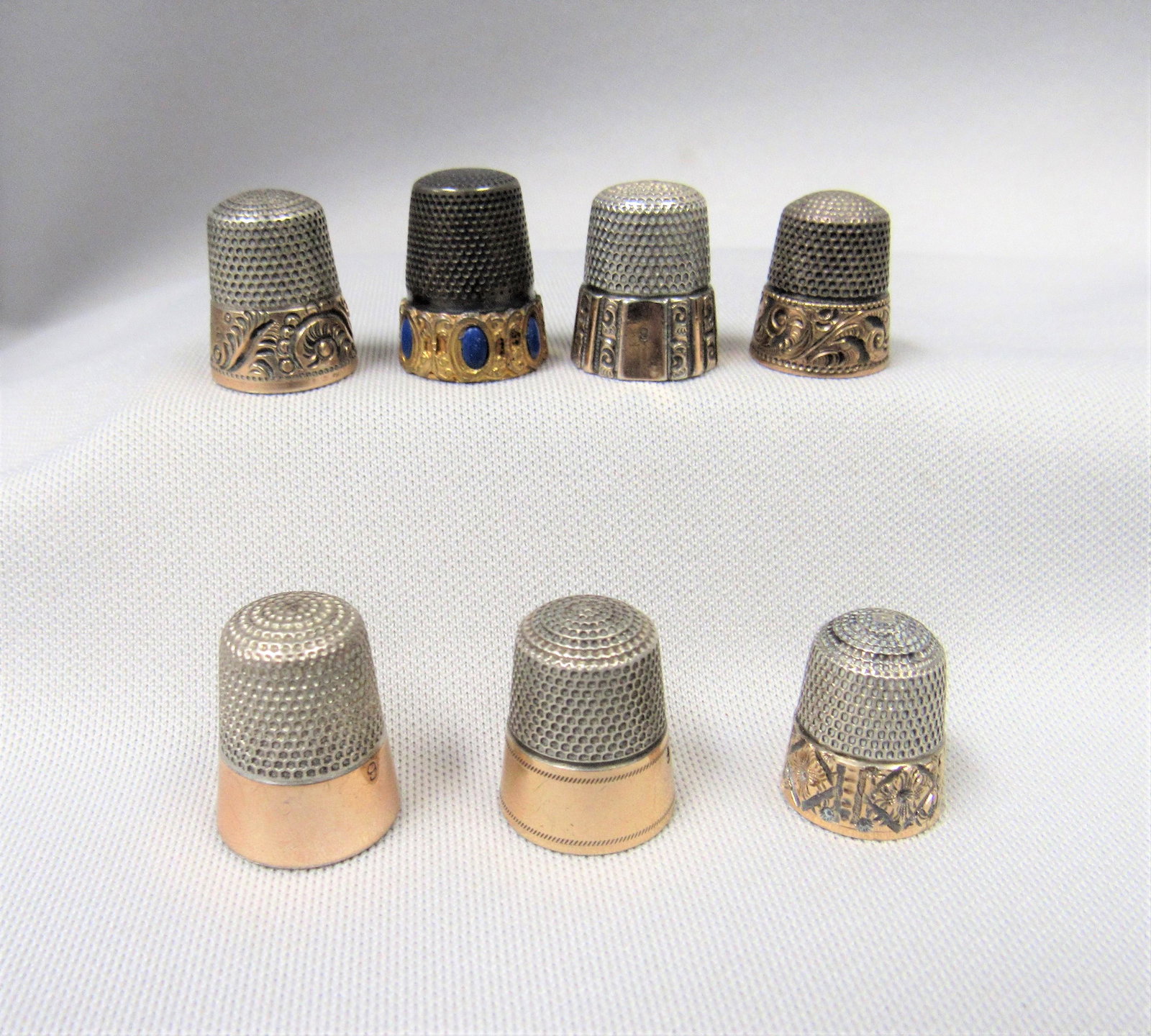 (7) SILVER THIMBLES WITH 10K GOLD BANDS:: 4 ARE MARKED STERLING, 1 MARKED 800, & 2 UNMARKED - G/VG