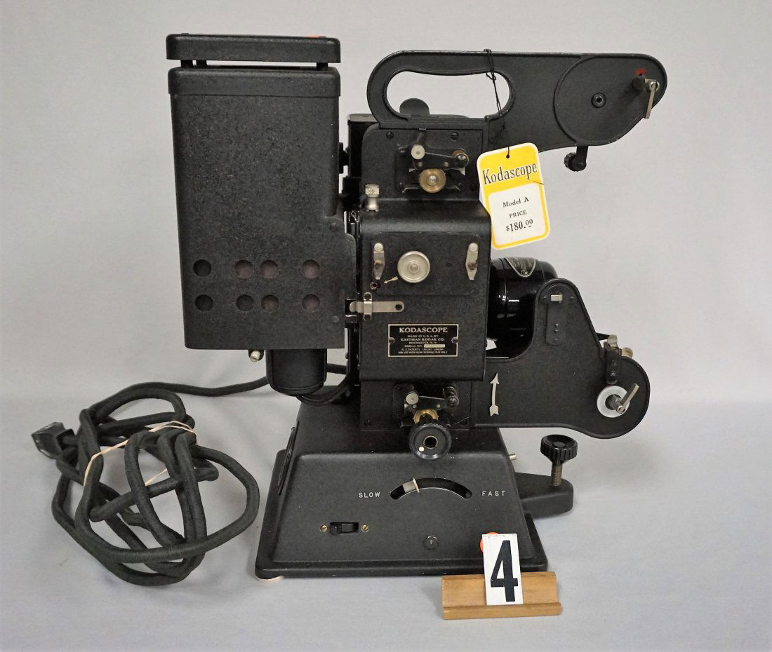 KODASCOPE MODEL A 16 MM MOVIE PROJECTOR,: WITH ORIGINAL HANG TAG, COMES WITH EASTMAN KODAK BOOKLETS, EXTRA MOVIE REELS, PROJECTOR LAMPS (BULBS), ALADDIN GEMS OF TRAVEL NO. 233 "A PEEK AT PARADISE" MOVIE REEL WITH ORIGINAL BOX, PROJECTOR IS IN