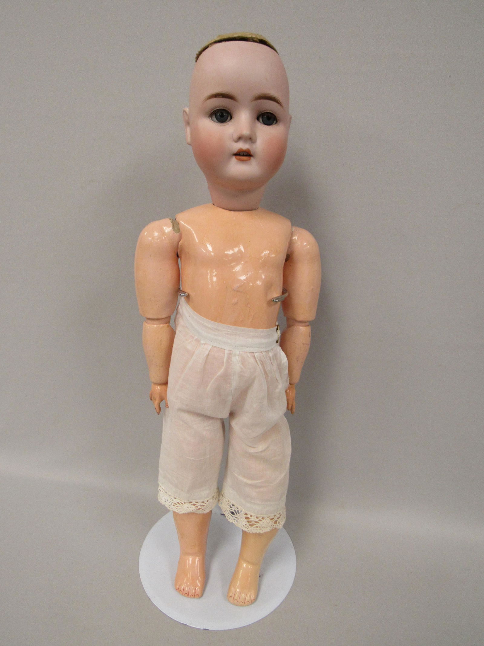 GEORGE BORGFELDT "PANSY" IV MARKED WITH NAME:: 23 IN. BISQUE HEAD WITH NO DAMAGE, SLEEP EYES WITH LASHES, BOTH ARMS HAVE CHIPPING AT BALL JOINT OF EACH SHOULDER. LOWER RIGHT LEG HAS CRACKING BUT NO PIECES MISSING OR LIFTING. MISSING A PIECE OF RIG