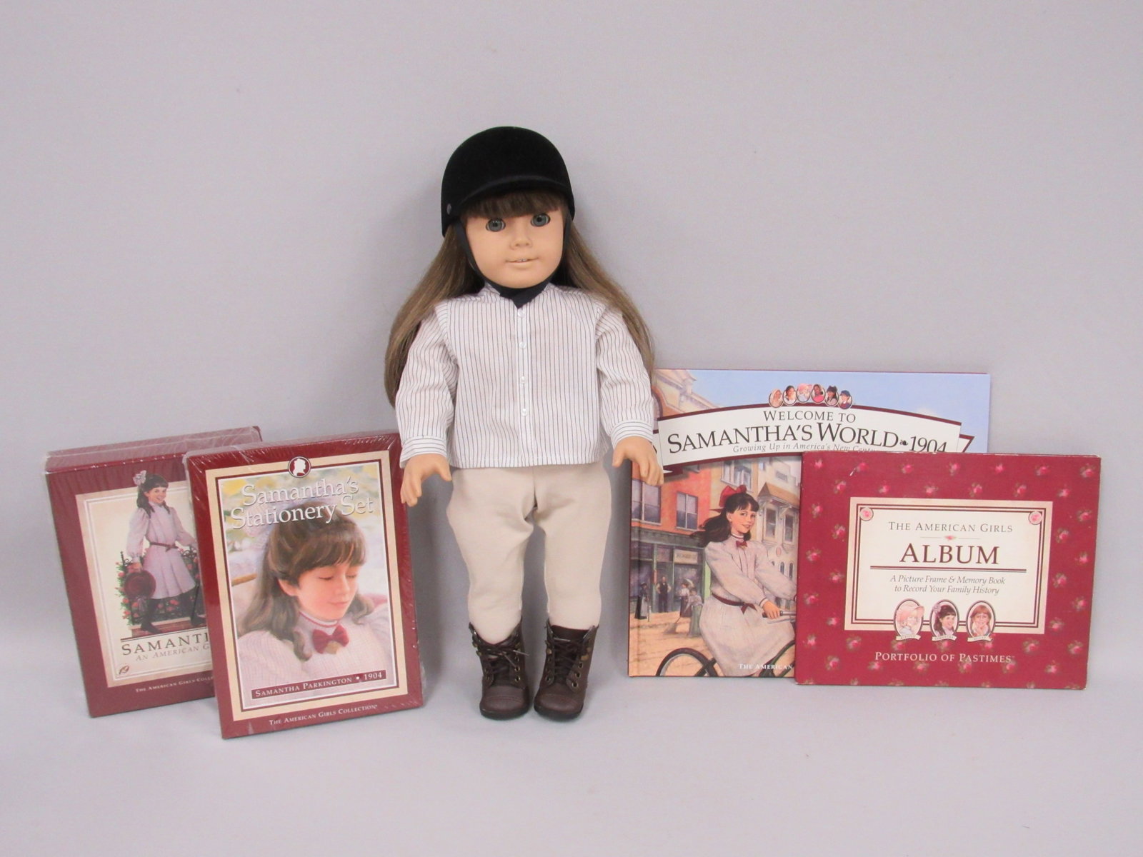 PLEASANT COMPANY "SAMANTHA" AMERICAN GIRL LOT:: DOLL IN RIDING OUTFIT (INCOMPLETE). SAMANTHA'S STATIONARY SET UNOPENED, BOOK - SAMANTHA'S WORLD, BOXED SET OF SAMANTHA BOOKS & AN AMERICAN GIRLS ALBUM OF FAMILY HISTORY - VG