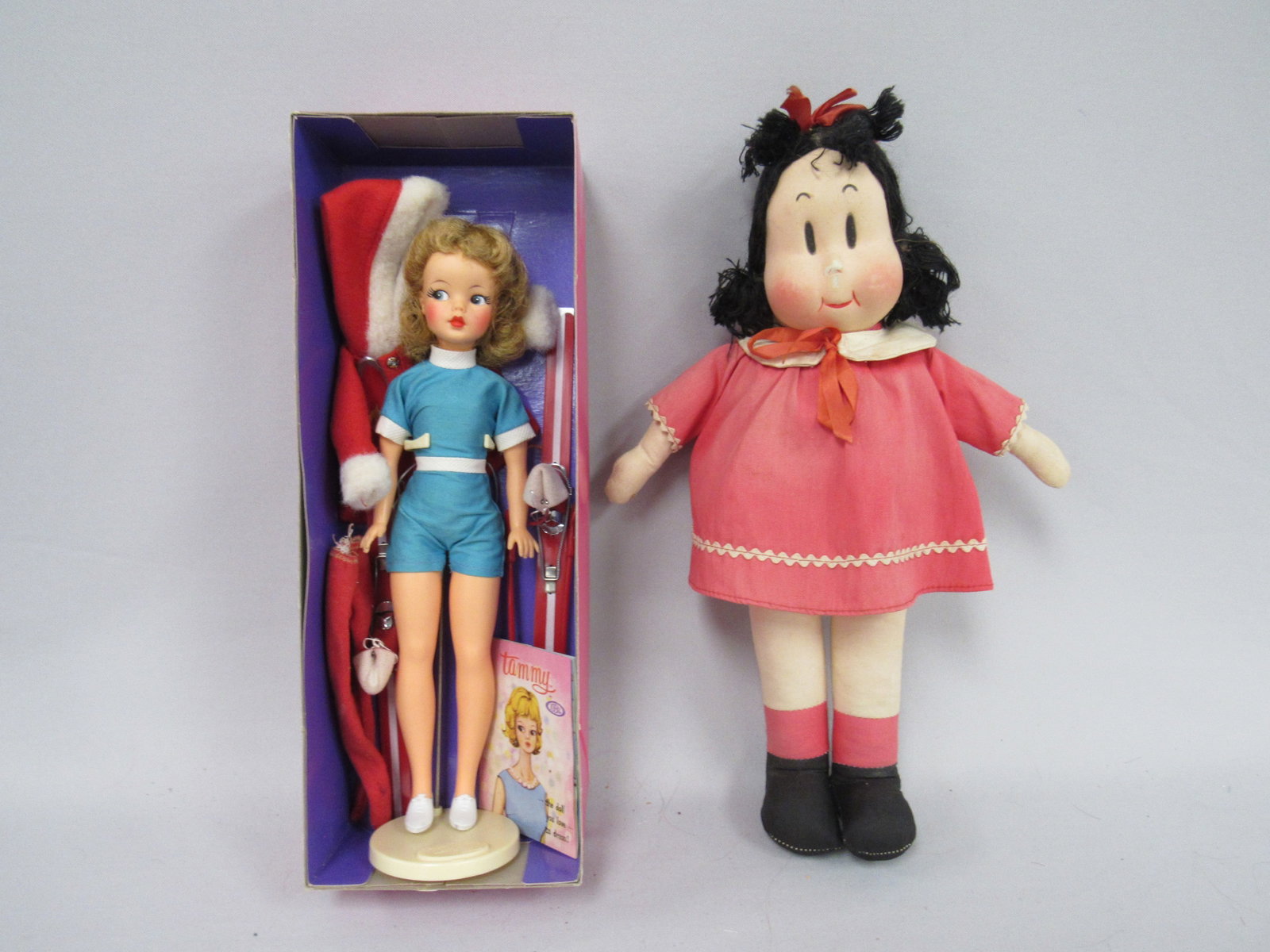 IDEAL TAMMY & LITTLE LULU:: TAMMY IS IN ORIGINAL OUTFIT WITH STAND SHOES & BOOKLET (MISSING LAST PAGE ALSO INCLUDES SKI OUTFIT, NO MITTENS) 14 IN. CLOTH "LITTLE LULU" BODY & DRESS FADED. FACIAL SCUFFS ON NOSE CHEEKS & UPPER LIP 